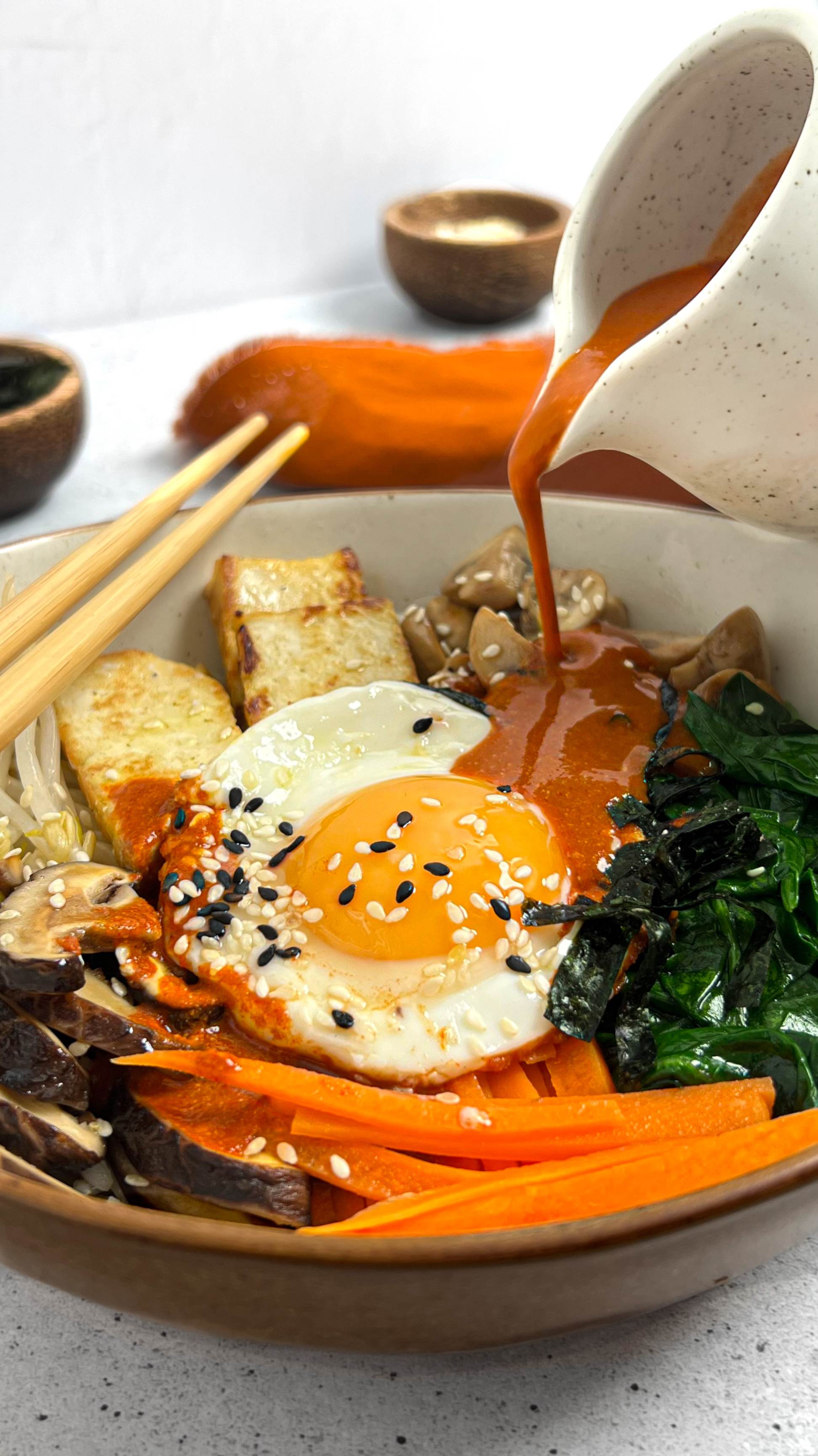Heartful Flavours Korean Bibimbap Recipe Lifestyle Shot with sauce pouring to dish